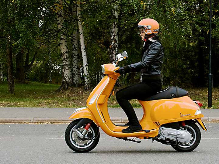 kuljettaja skootterin kyydissä